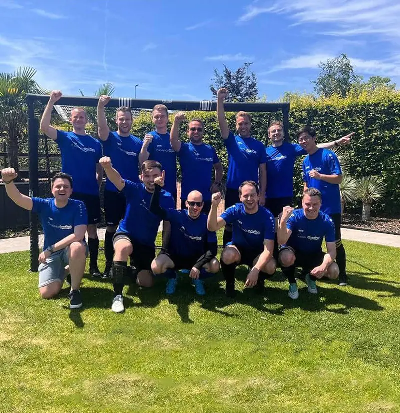 Team van Twentecs-collega's in blauwe voetbalshirts na een bedrijfsvoetbalwedstrijd