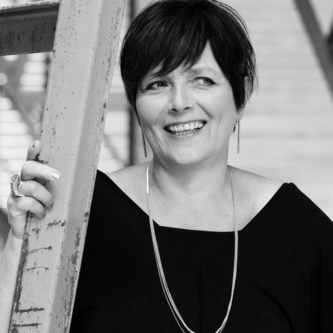 Zwart-wit portret van een lachende vrouw, klantverhaal Van Campen Consulting