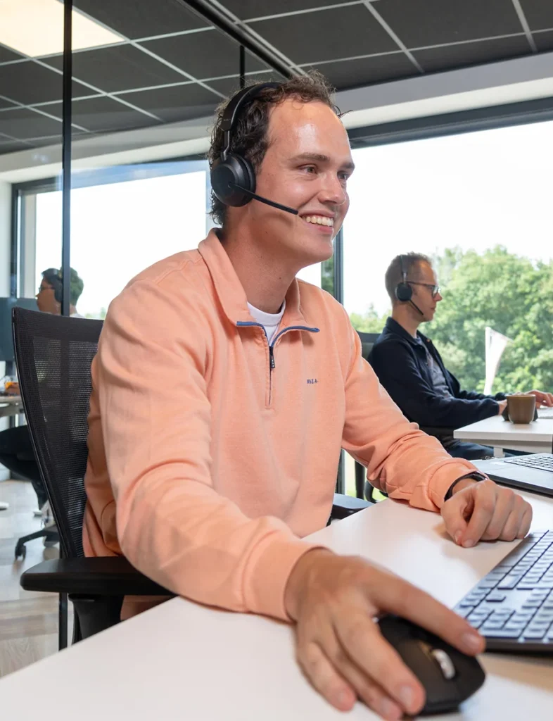 Medewerker van Twentecs met headset achter een laptop