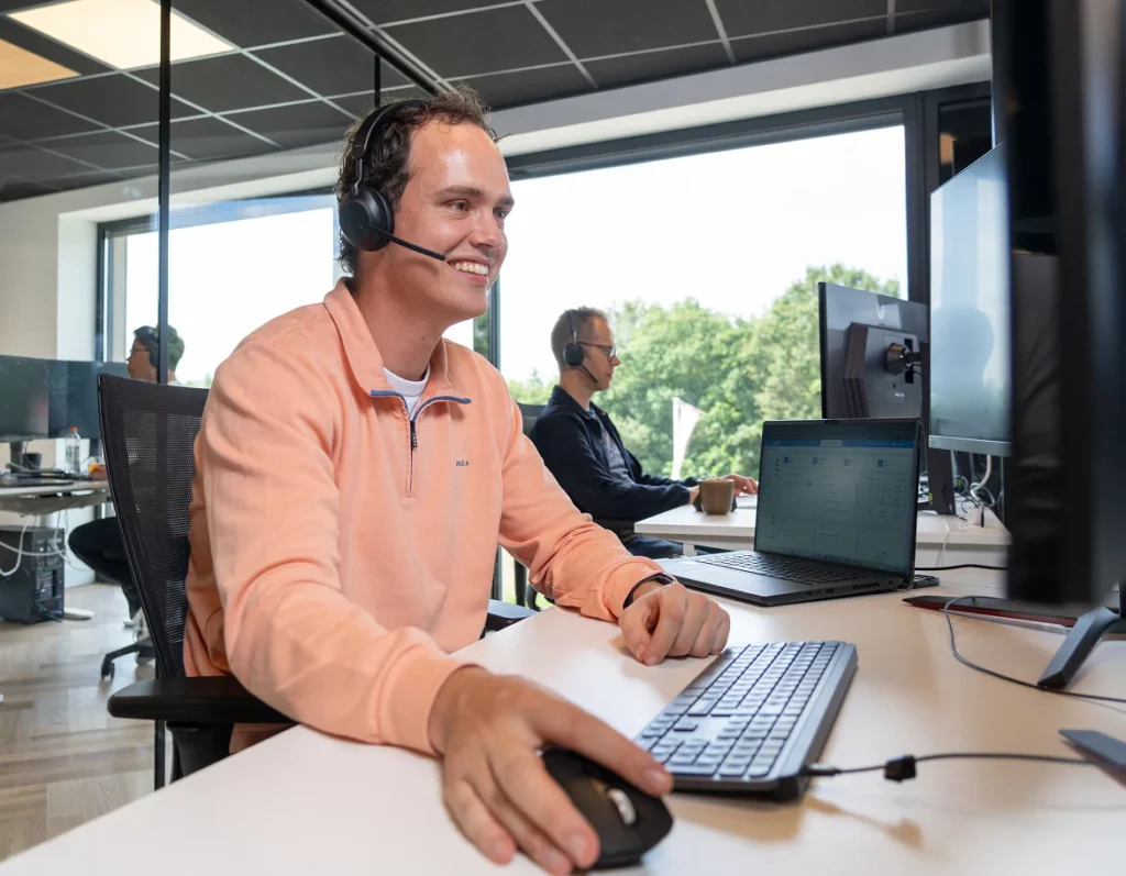 Medewerker van Twentecs met headset achter een computerscherm