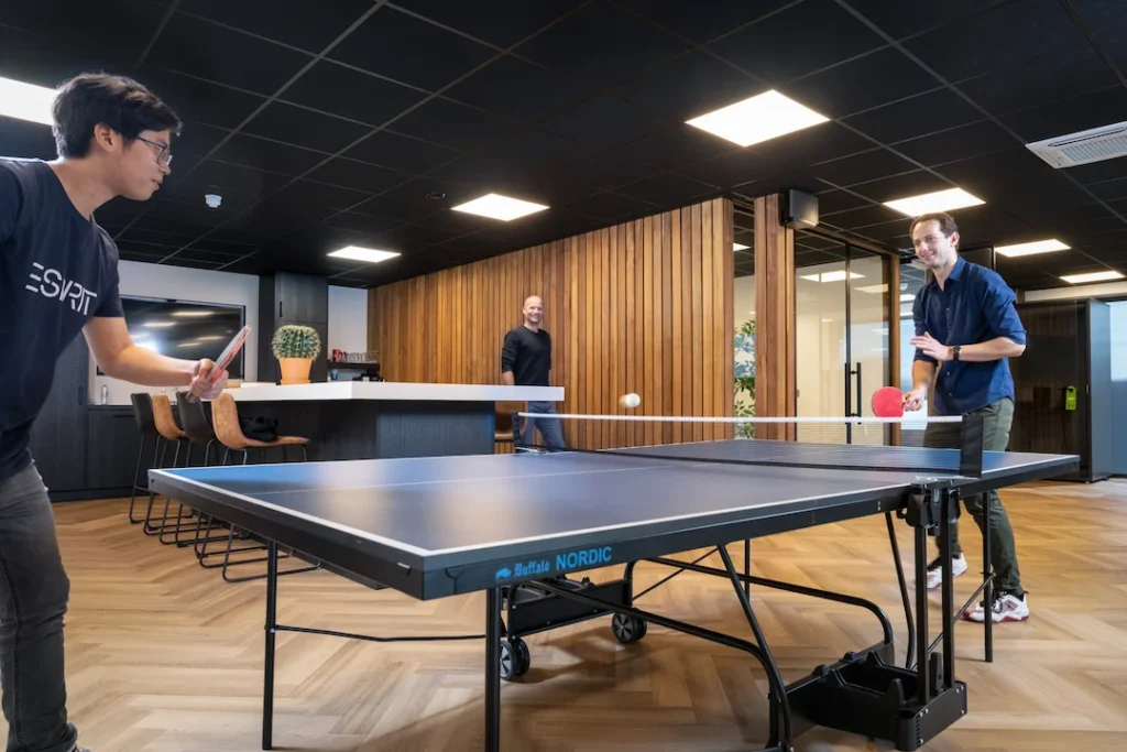 Twee collega's van Twentecs die tafeltennissen in een kantoorruimte